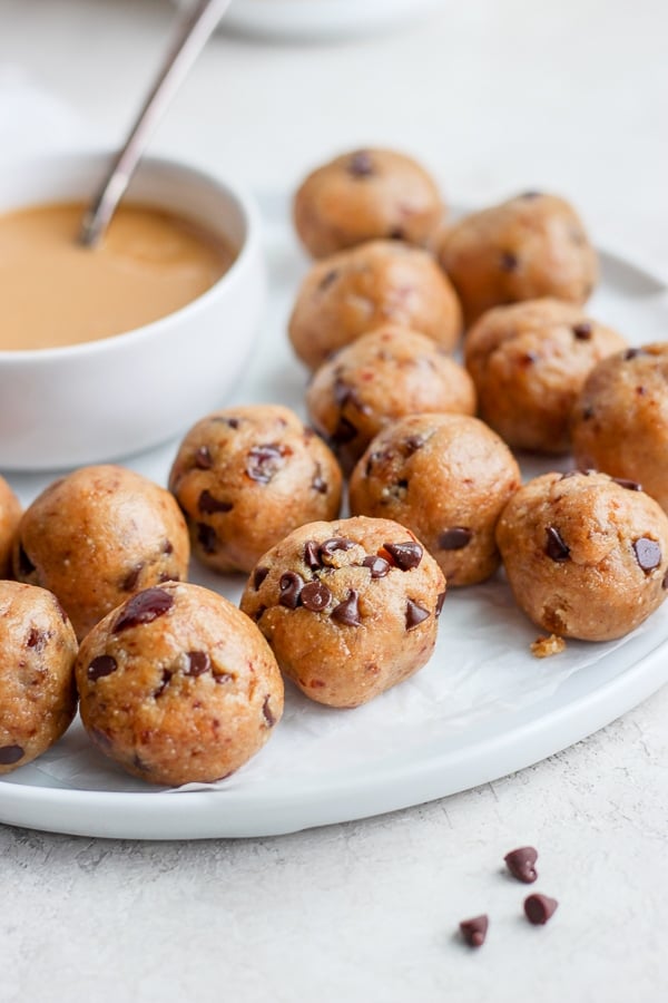 Rolled cookie dough bites on a large white plate.