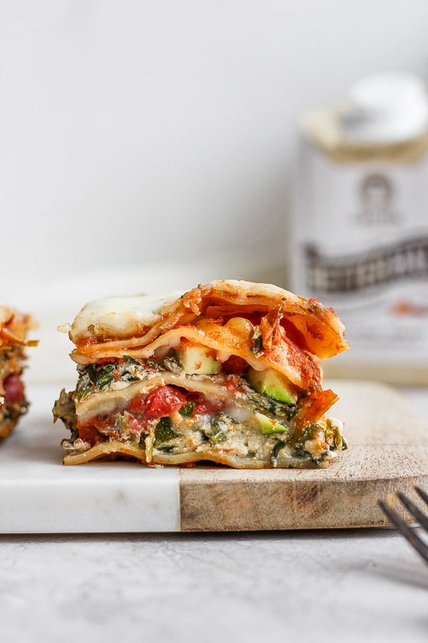 A piece of dairy free lasagna on a cutting board.