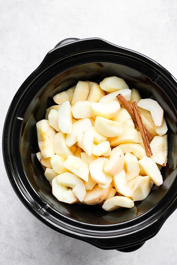 Peeled and sliced apples in a slow cooker. 