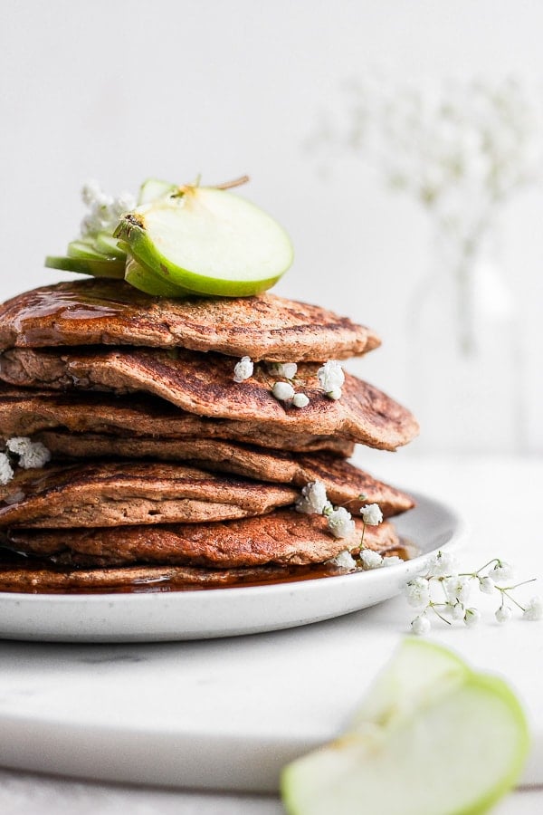 A stack of apple pancakes on a white plate.