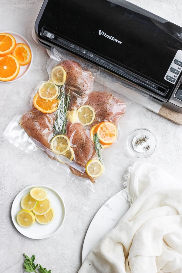 FoodSaver bags of chicken breasts being sealed by a FoodSaver preservation system.