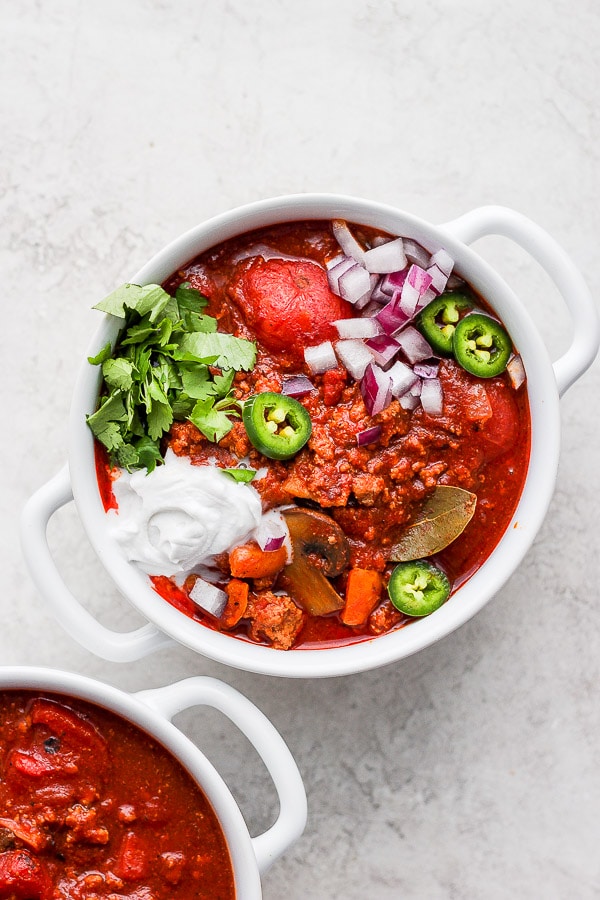 A bowl of chili with toppings.