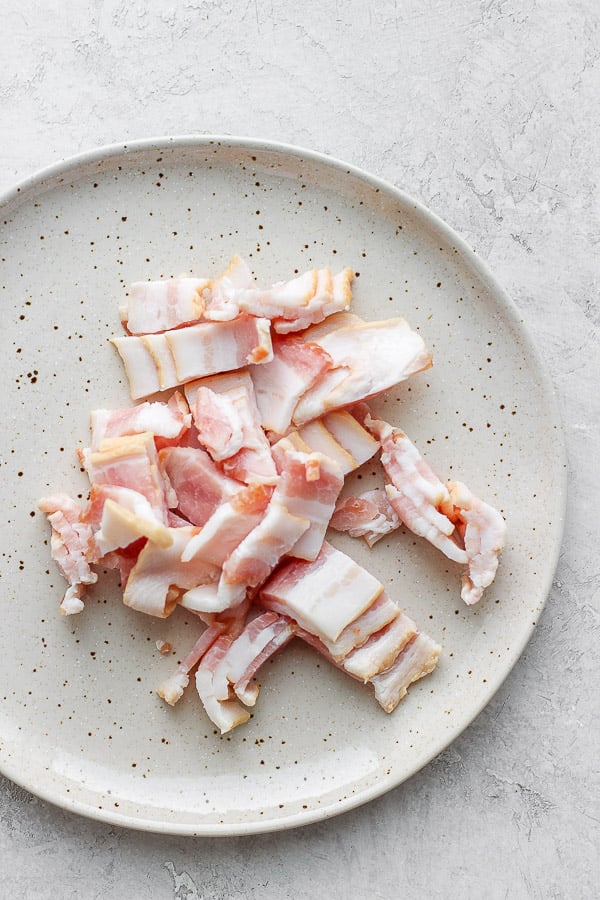 Chopped slices of bacon on a plate.