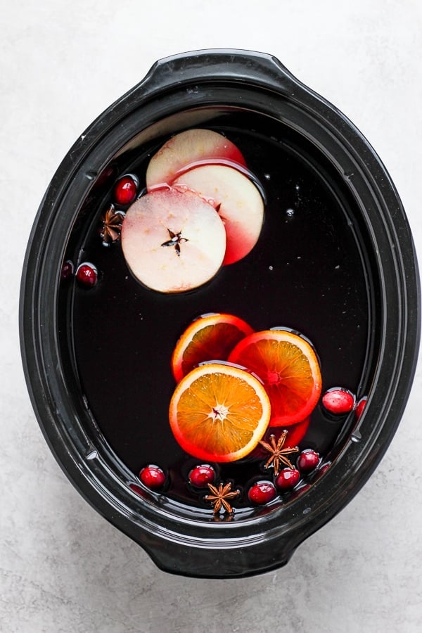 All ingredients for mulled wine in a slow cooker.