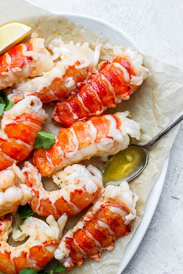 Butter poached lobster tails on parchment paper.