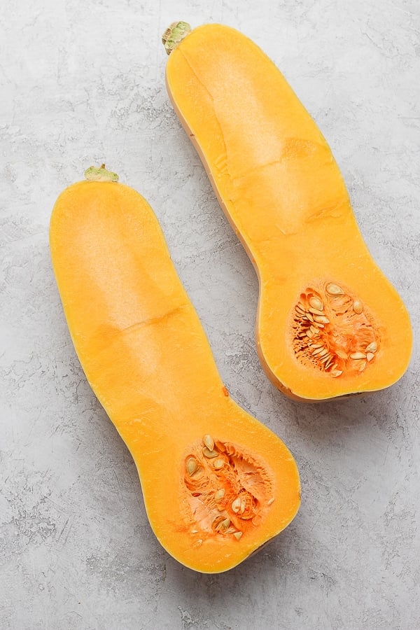 A butternut squash cut in half, lengthwise.