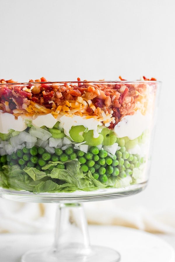 Close up of a seven layer salad in a glass dish.