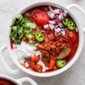 A bowl of turkey chili with jalapenos and sour cream.