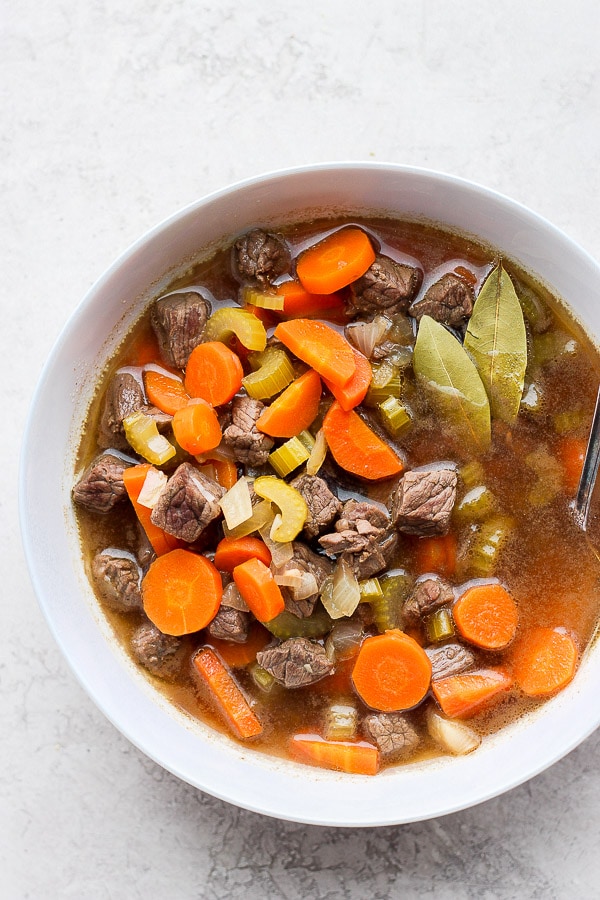 Beef vegetable soup in a white bowl.