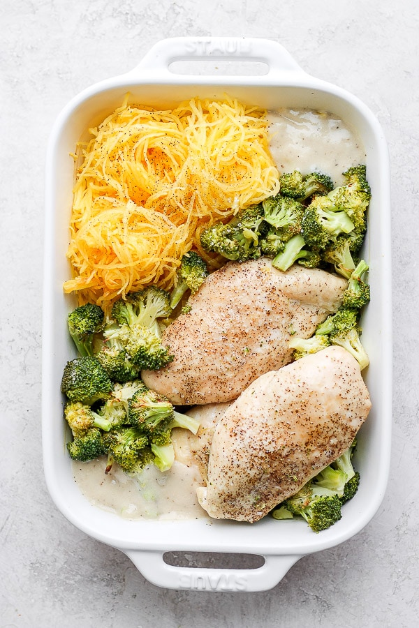 White baking dish to show the chicken breasts, broccoli, spaghetti squash, and Alfredo sauce.