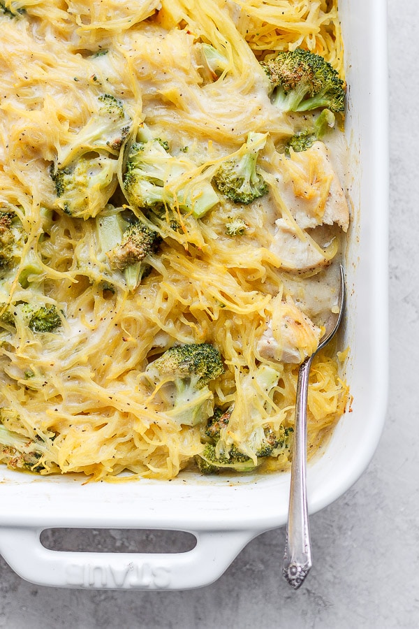 Fully baked chicken broccoli alfredo bake with a spoon in it.
