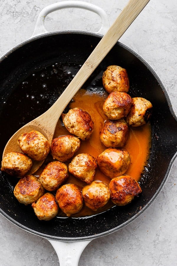 Buffalo chicken meatballs in a cast iron skillet. 