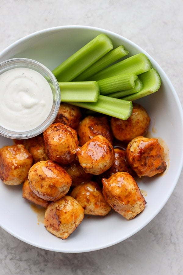 Buffalo chicken meatballs in a bowl with ranch and celery. 