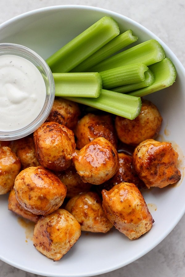 Buffalo chicken meatballs in a bowl with ranch and celery. 