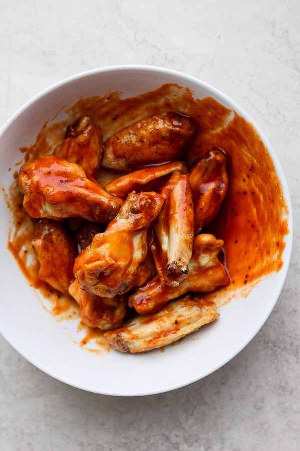 Honey bbq wings in a large white bowl.