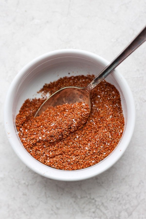 Bowl of homemade taco seasoning with spoon sticking out. 