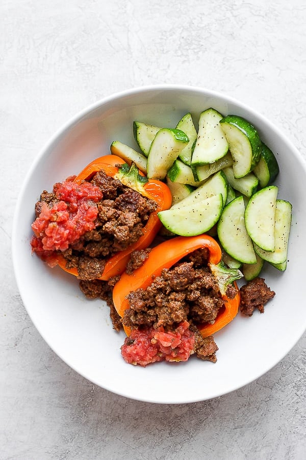 Bowl of taco stuffed peppers with salsa and some sauteed zucchini.