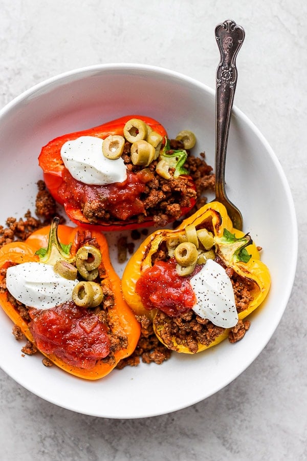 Bowl of taco stuffed peppers with salsa, green olives and sour cream. 