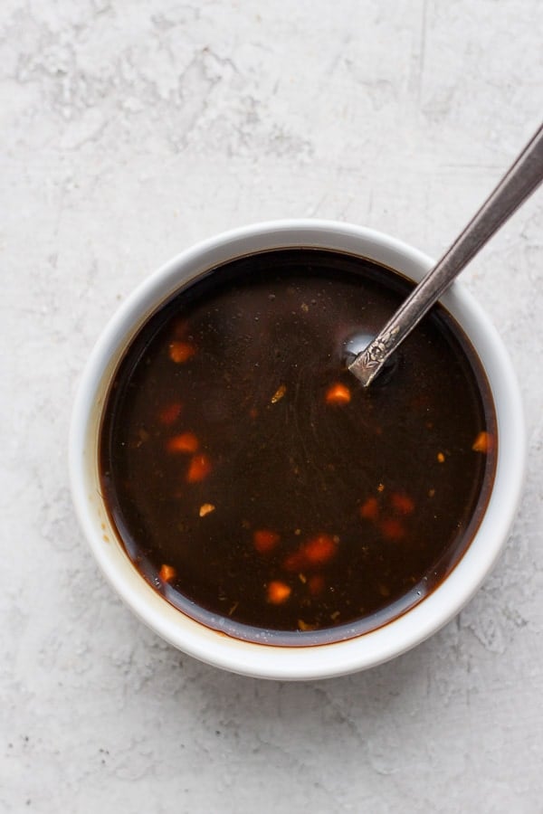 Paleo Teriyaki Sauce in a bowl with a spoon sticking out. 