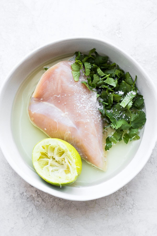 Raw chicken sitting in a cilantro lime marinade. 