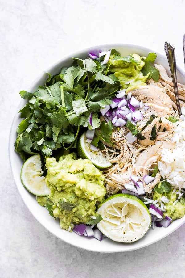 Cilantro lime chicken on top of a rice bowl with fresh toppings.