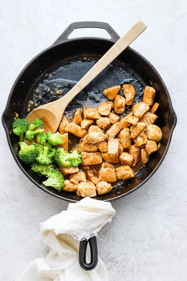 Healthy orange chicken and broccoli in a large cast iron skillet. 