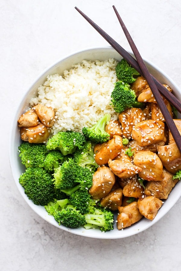 Bowl of Healthy Orange Chicken with broccoli and cauliflower rice.