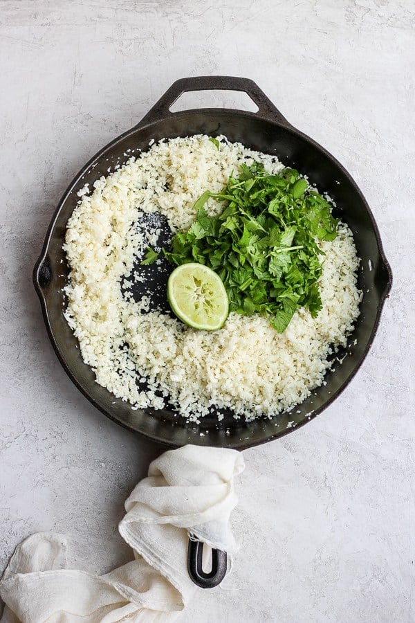 Cilantro lime cauliflower rice in a cast iron skillet. 