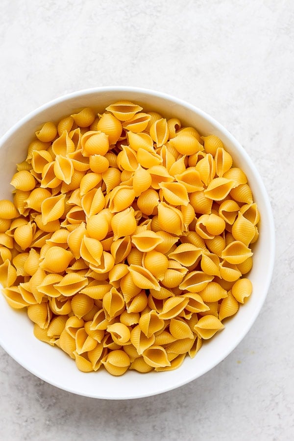 Dry shell pasta in a large bowl.