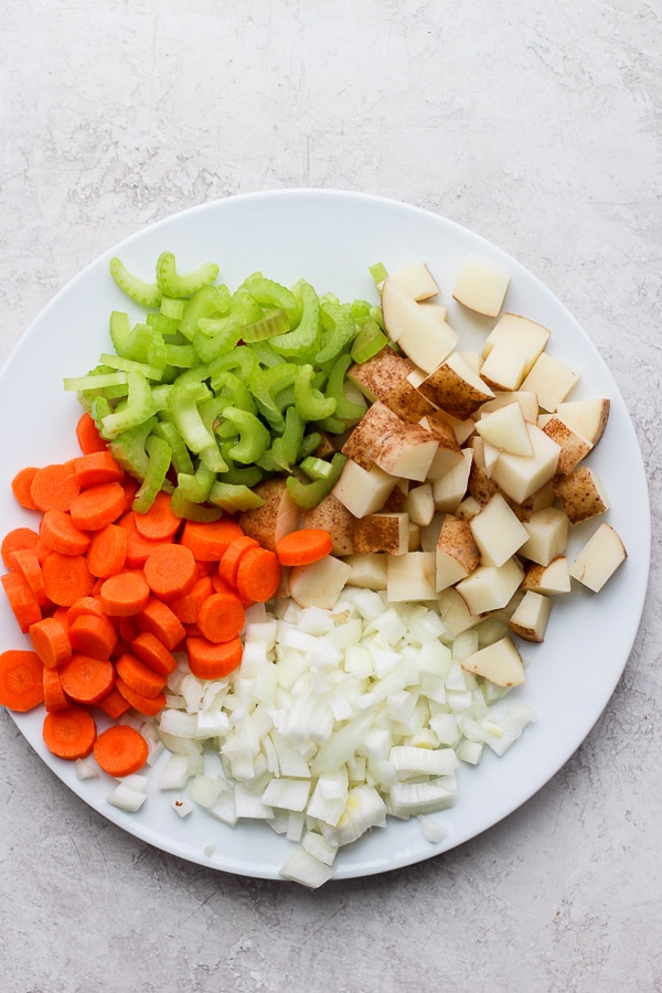 Fresh vegetables cut-up on a white plate.