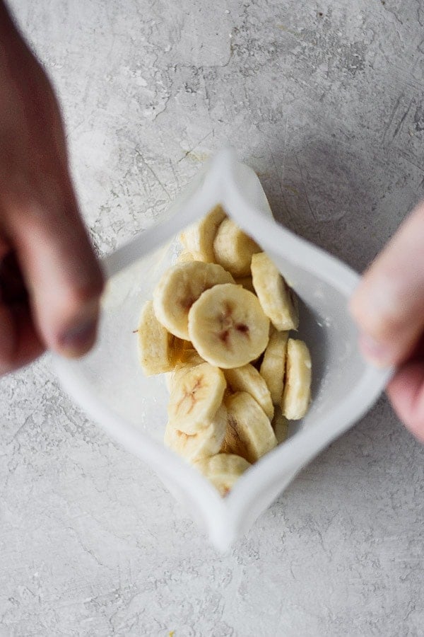 Frozen banana slices in a reusable silicone bag.