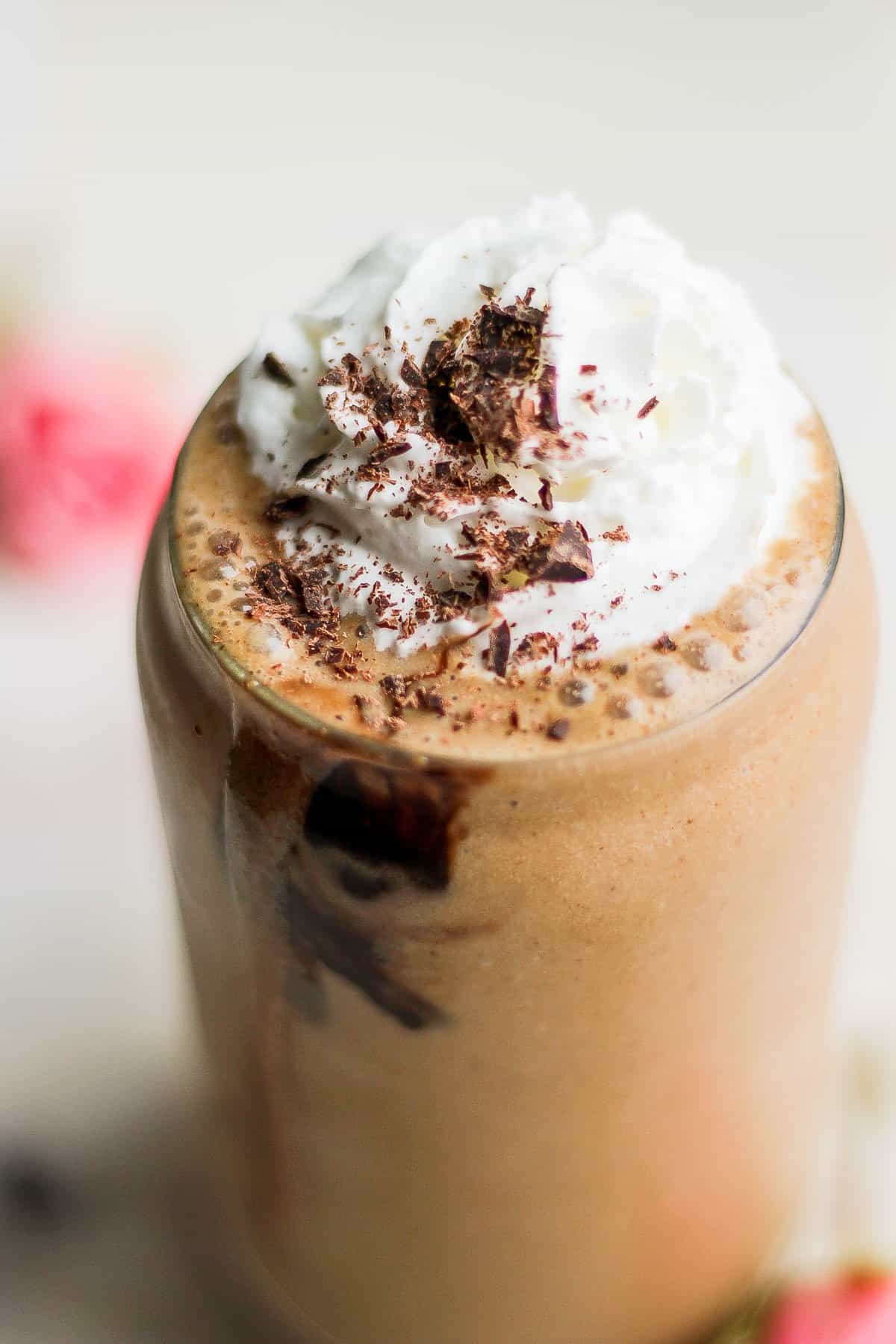 Close up shot of dairy free whipped cream and chocolate shavings on top of the smoothie. 