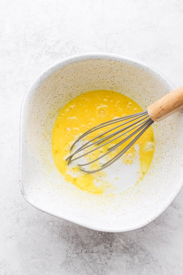 A whisk combining the eggs and almond milk.
