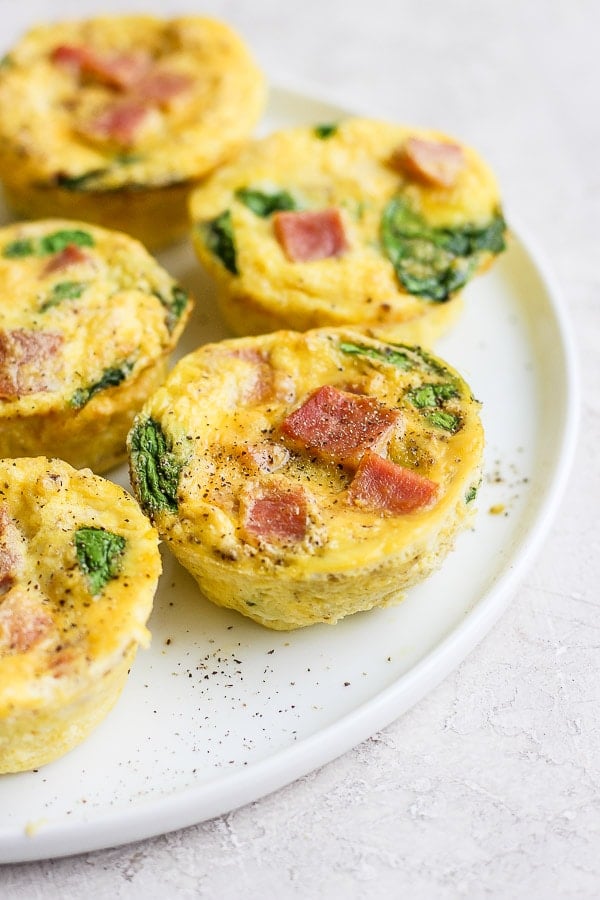 Egg cups sprinkled with salt and pepper on a plate.