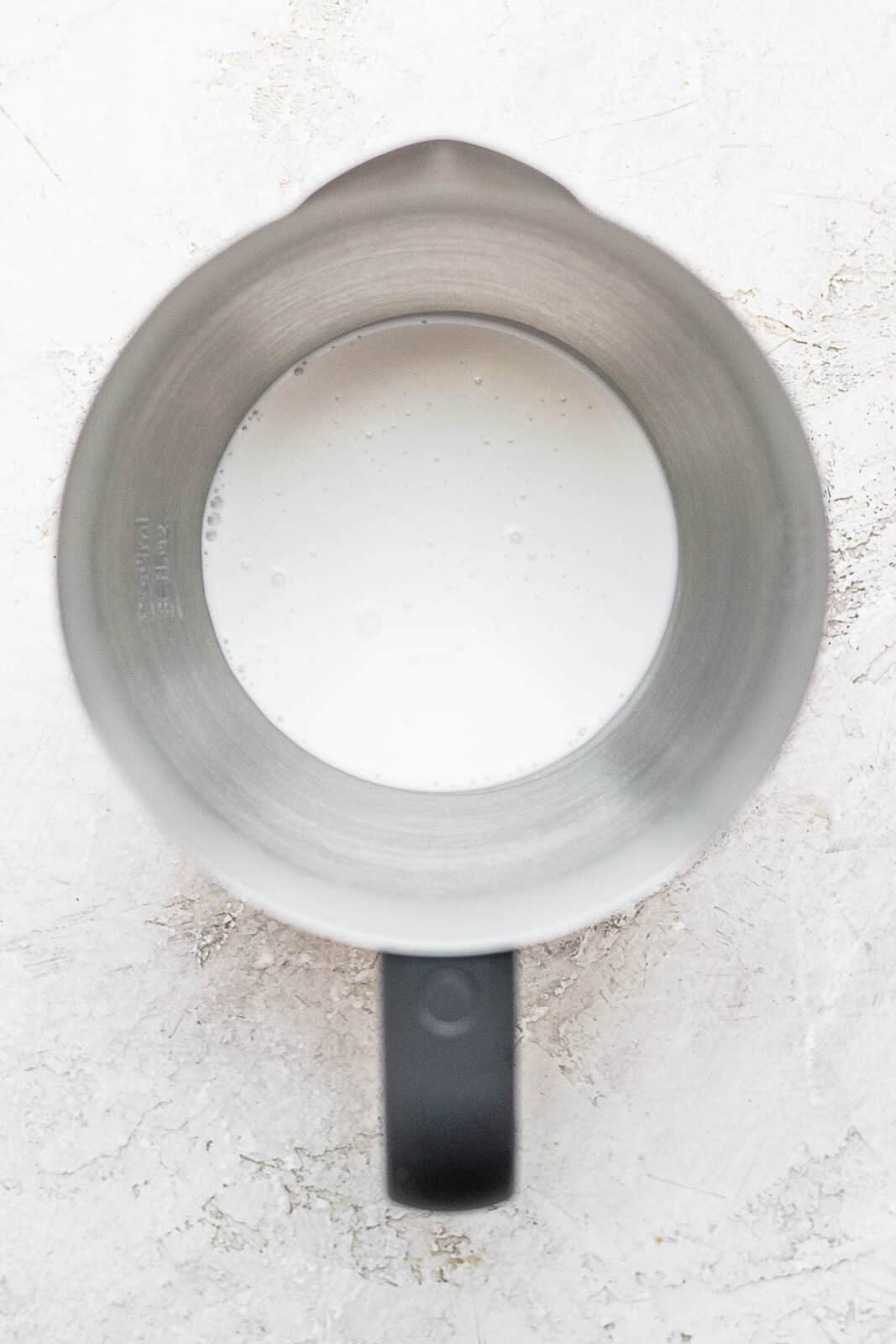 Top shot of a frother with coconut milk in it. 
