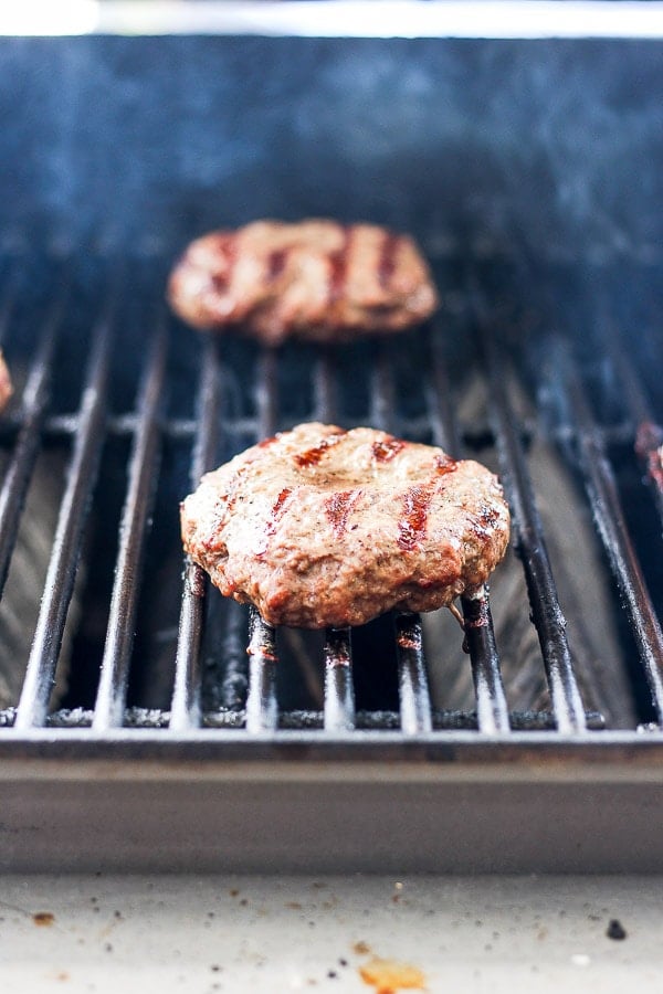 A burger sitting on the grill. 