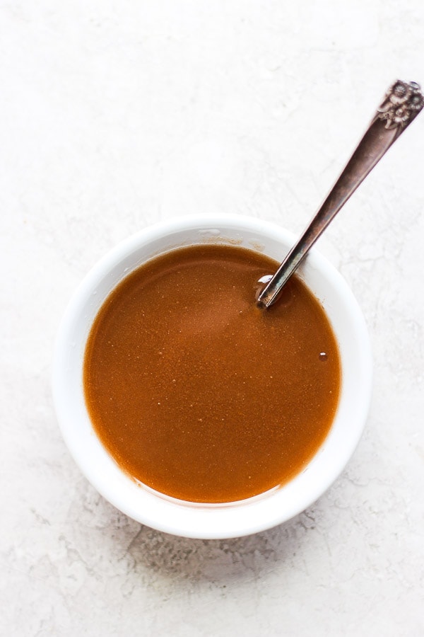 Cup of balsamic dressing with a spoon.