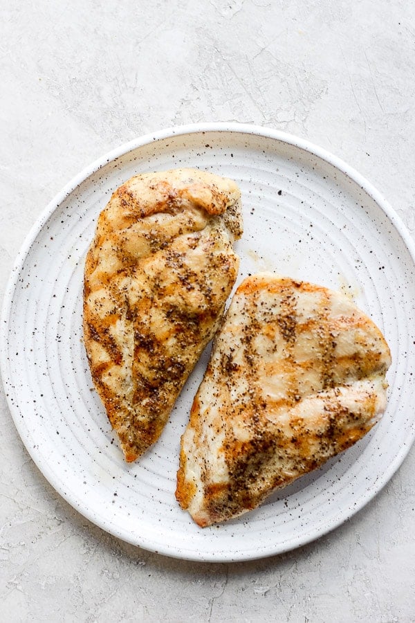 Two grilled chicken breasts on a plate. 