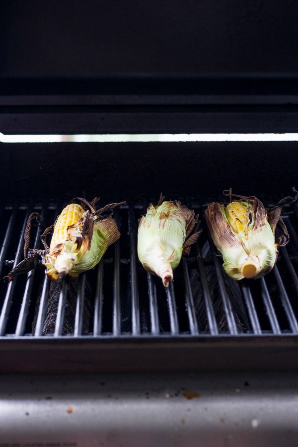 Three pieces of corn on the cob on the grill. 