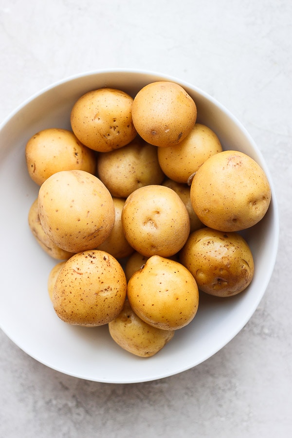 Clean Yukon gold potatoes in a white bowl.
