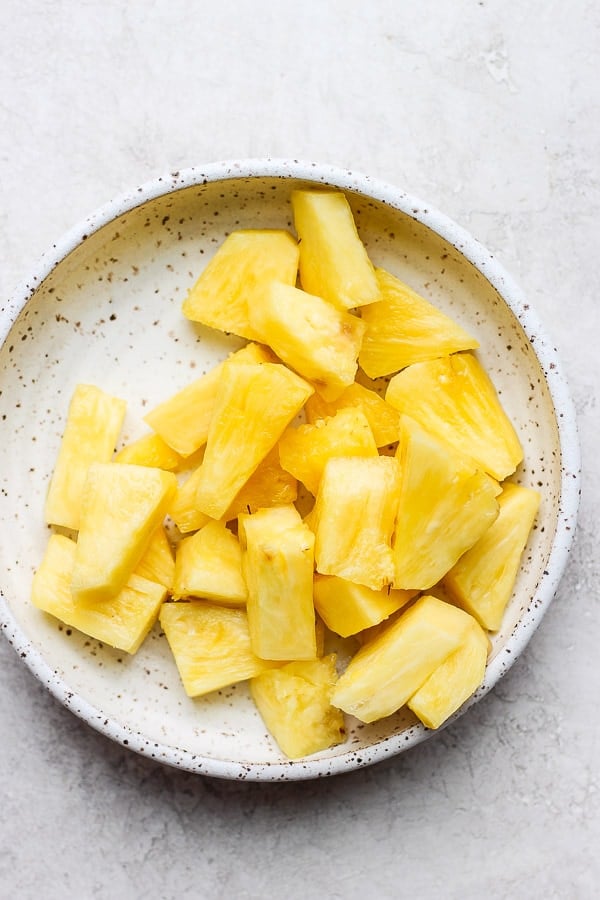 Fresh pineapple chunks in a shallow bowl.