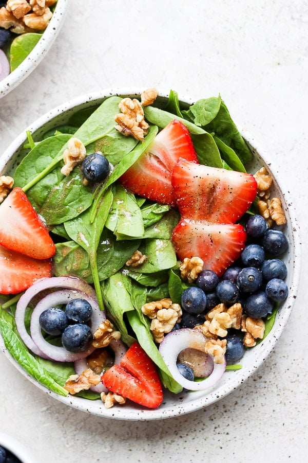 A bowl of strawberry spinach salad.