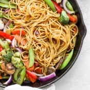 A cast iron skillet full of veggie lo mein.