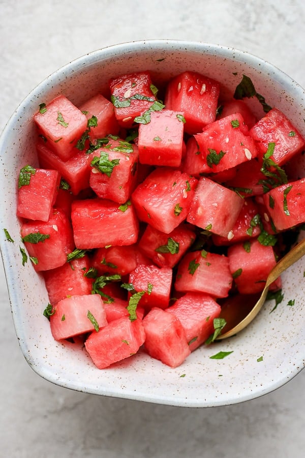 A fully mixed watermelon mint salad in a large bowl.
