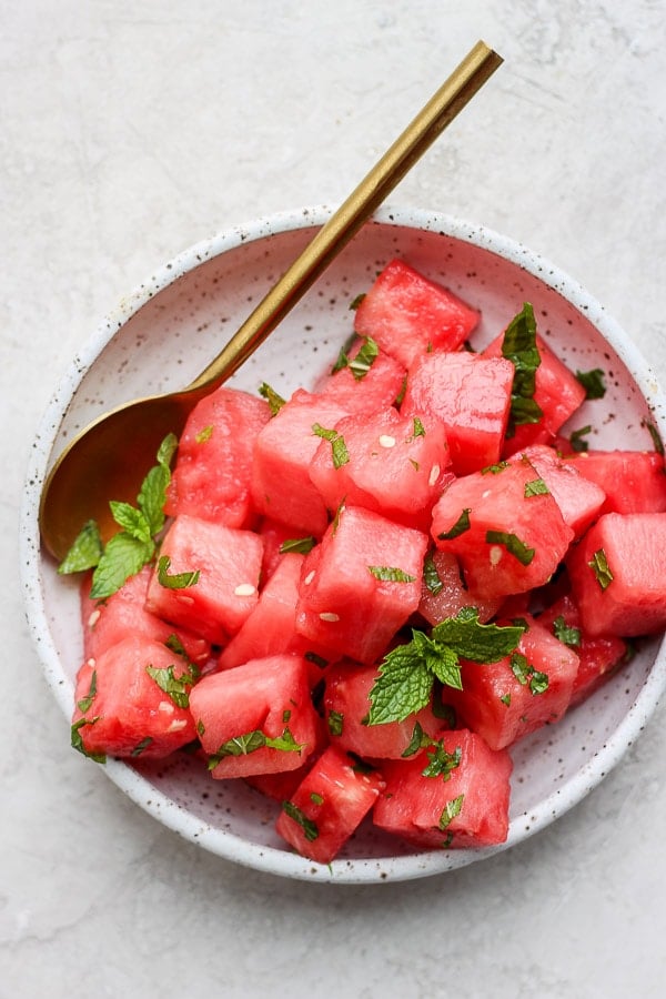 Watermelon mint salad on a plate with a spoon.