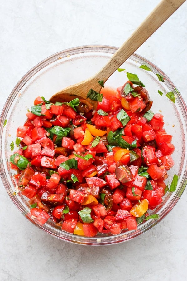 Fully mixed bruschetta mix in a glass bowl.