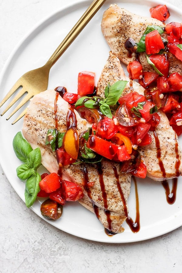 Bruschetta chicken on a white plate.