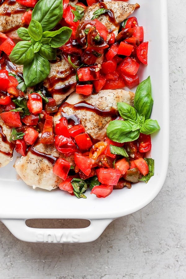 Bruschetta chicken in a white baking dish.