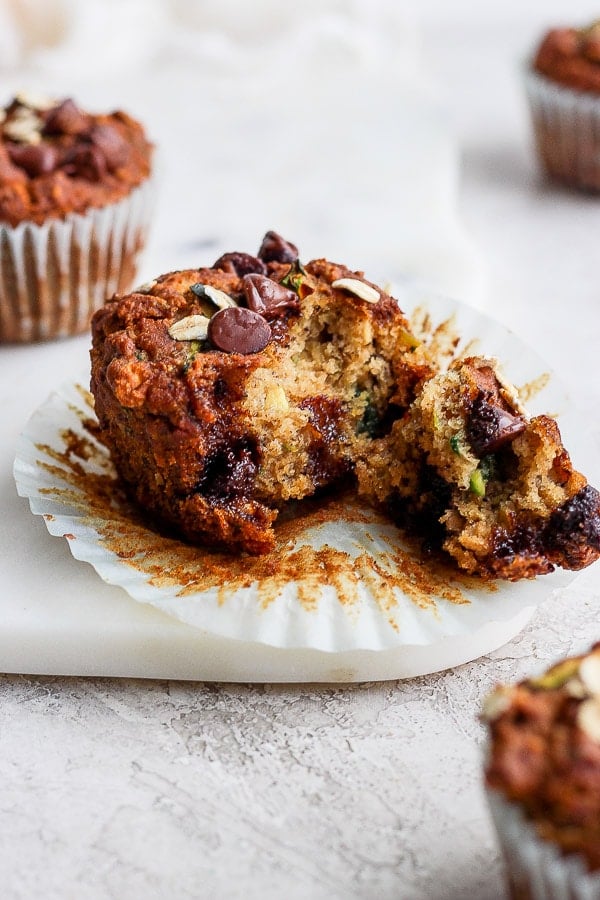 A healthy zucchini muffin with a bite taken out of it.