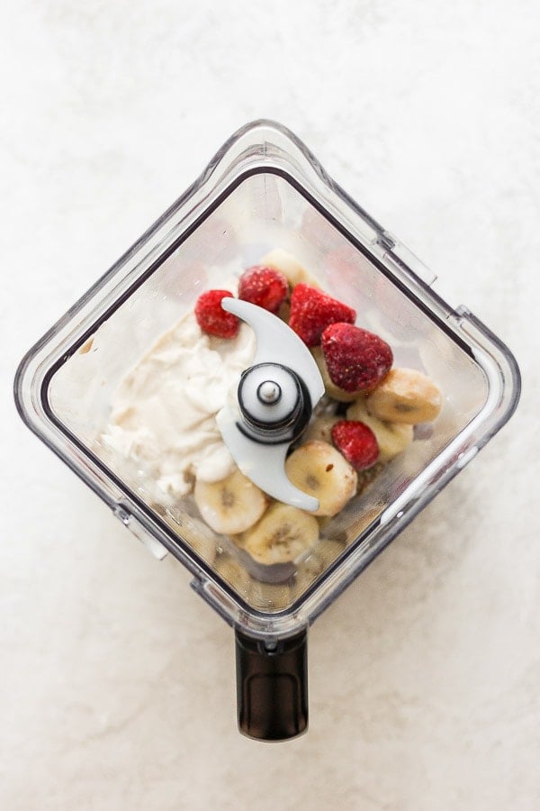 Strawberry smoothie ingredients in a blender.